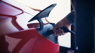 A view of a person’s hand charging a car