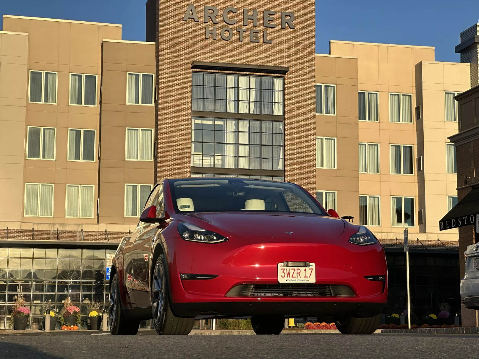 A picture of the red tesla car near Archer Hotel