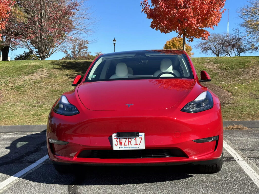 A picture of the red tesla car parked in the parking lot